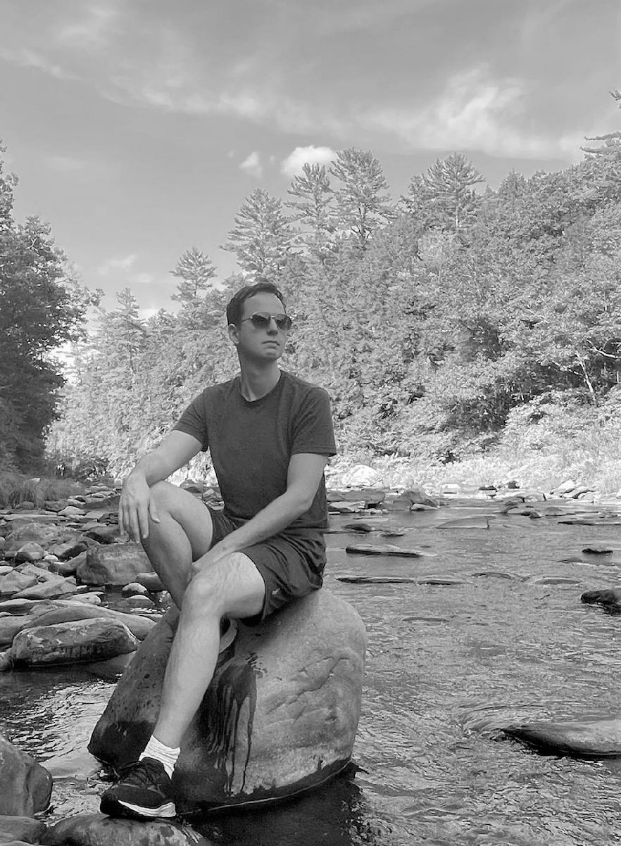 Dave sitting on a rock in a river